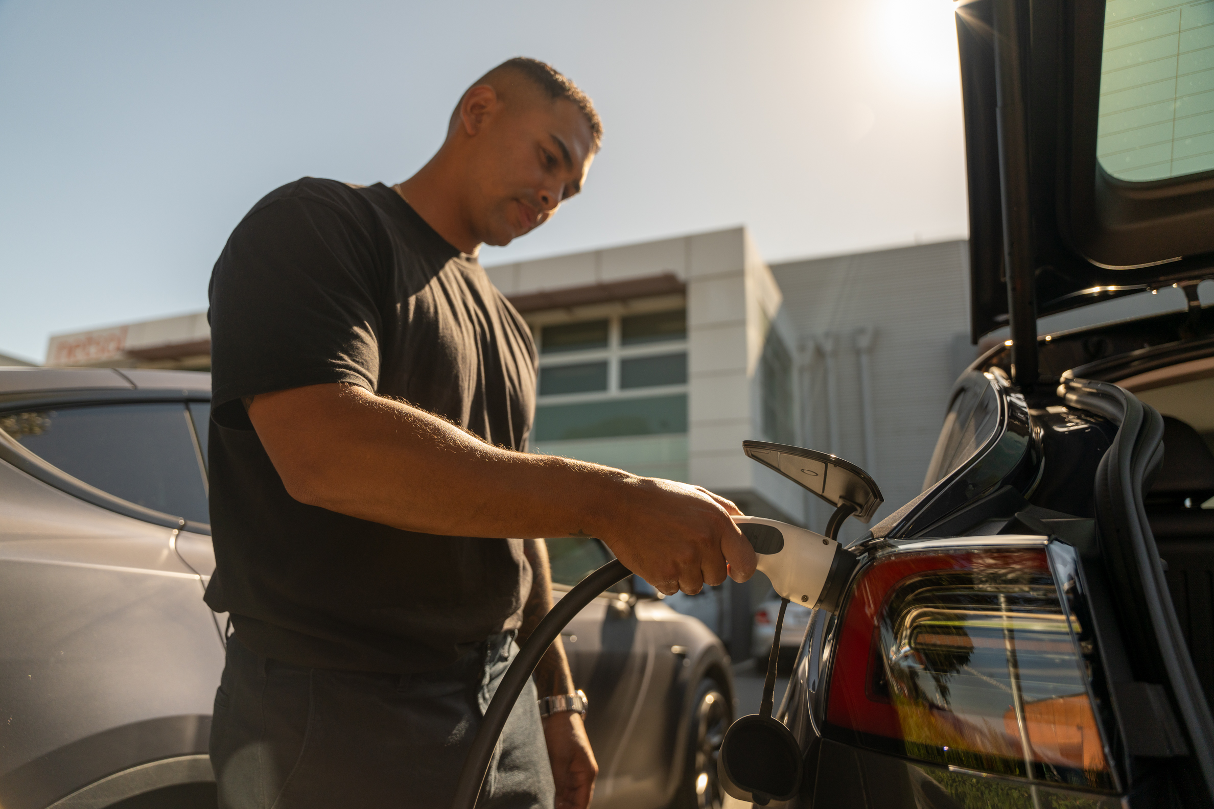 Man charging electric vehicle
